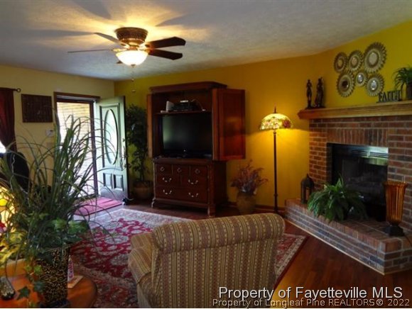 6400 Faircloth Bridge Road Stedman, NC 28391 - Photo 3 of 19 a living room with furniture a flat screen tv and a fireplace
