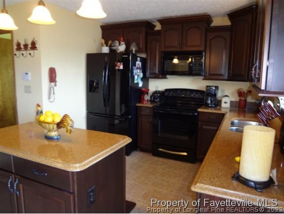 6400 Faircloth Bridge Road Stedman, NC 28391 - Photo 7 of 19 a kitchen with a sink refrigerator and microwave