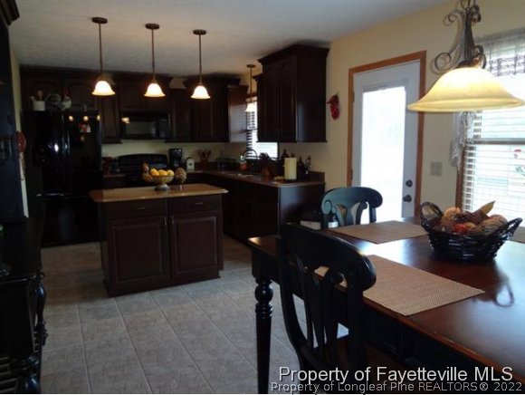 6400 Faircloth Bridge Road Stedman, NC 28391 - Photo 10 of 19 a kitchen with stainless steel appliances granite countertop a sink dishwasher a stove a refrigerator a dining table and chairs with wooden floor