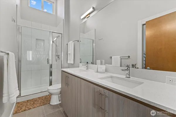 a bathroom with a double vanity sink toilet and shower