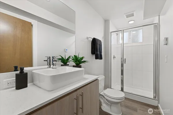 a bathroom with a sink a toilet and shower