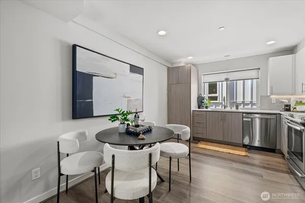 a kitchen with a dining table chairs and white cabinets