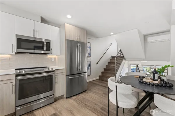 a kitchen with a stove a microwave and furniture