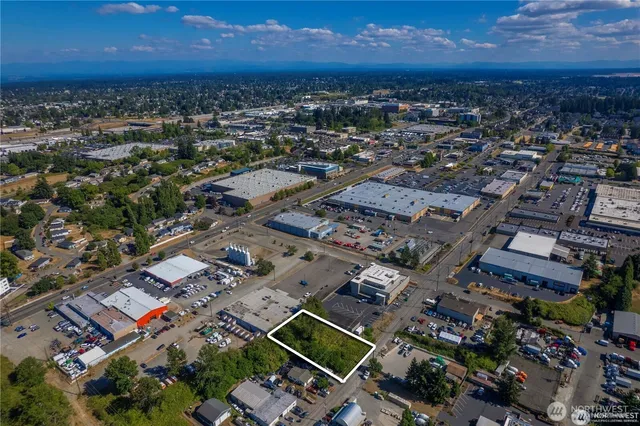 an aerial view of a city with lots of residential buildings and mountain view in back