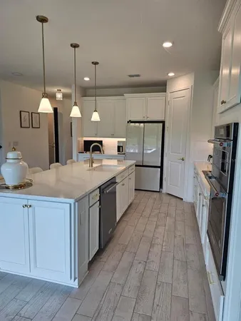 a kitchen with stainless steel appliances granite countertop a sink a stove and a wooden floors