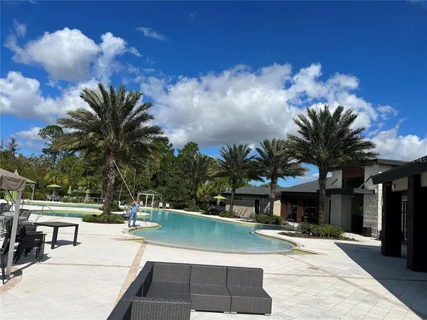 a view of a house with a swimming pool and sitting area