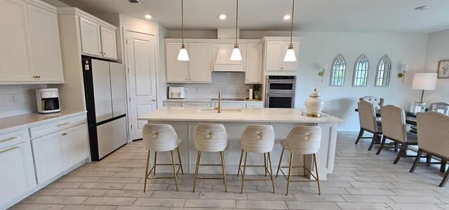 a large kitchen with a table and chairs