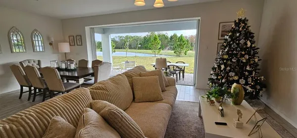 a living room with furniture a chandelier and a window
