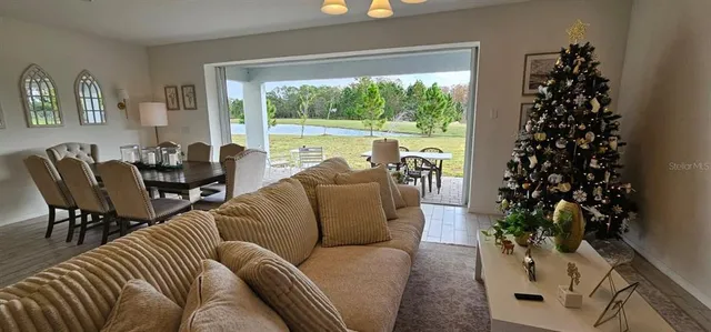 a living room with furniture a chandelier and a window