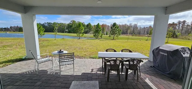 a view of a chairs and table in patio with a lake view