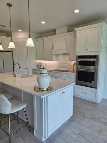 a kitchen with kitchen island a sink stove and oven