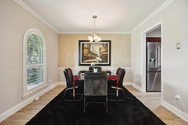 a dining room with furniture a chandelier and wooden floor