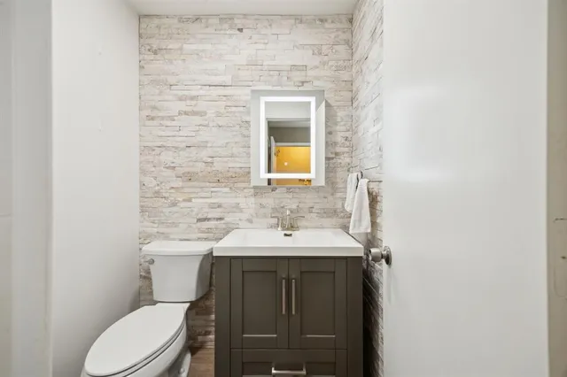 a bathroom with a toilet sink and mirror