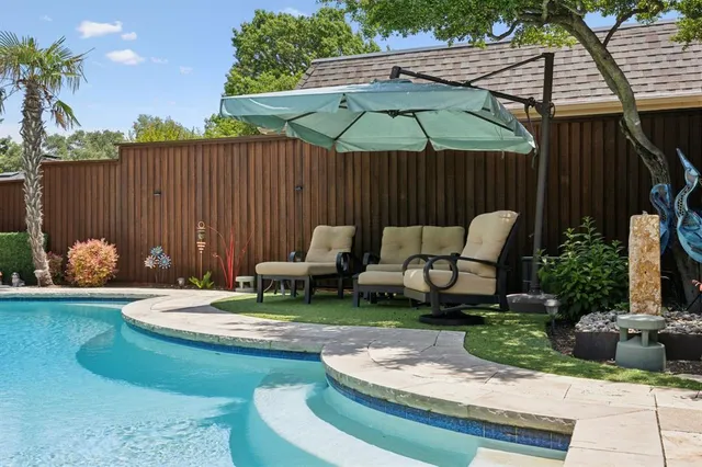 a view of a swimming pool with a patio and a fire pit
