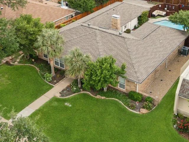a front view of a house with a garden and trees