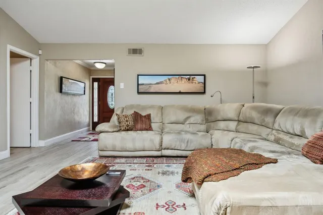 a living room with furniture and a wooden floor