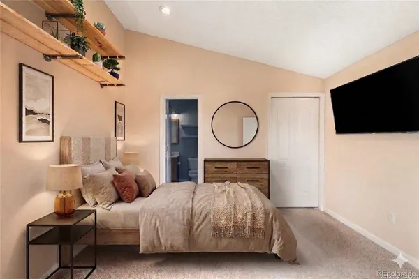 a bedroom with a bed a mirror on the wall and a flat screen tv