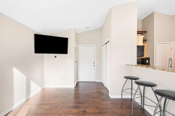 a view of a livingroom with wooden floor and a flat screen tv