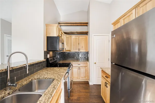 a kitchen with a refrigerator sink and cabinets