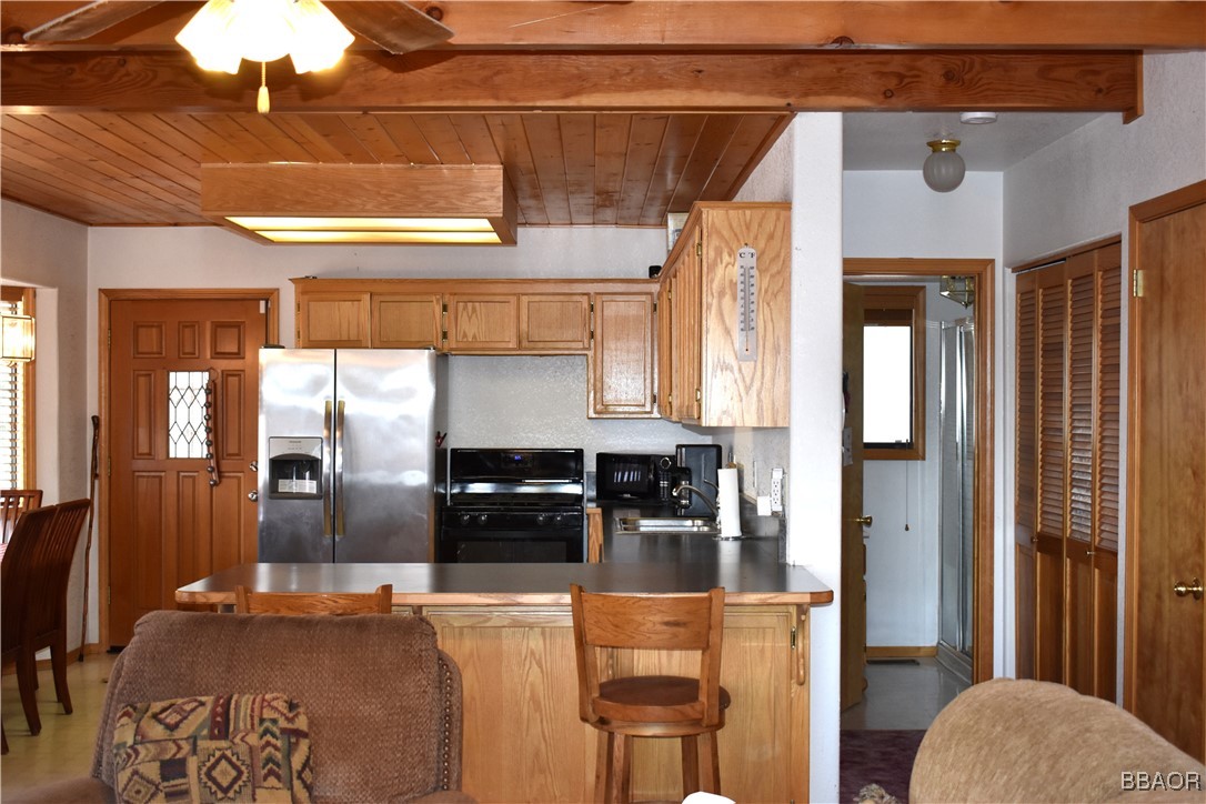 442 Inyo Avenue Sugarloaf, CA 92386 - Photo 10 of 36 a kitchen with stainless steel appliances kitchen island granite countertop a refrigerator and a stove