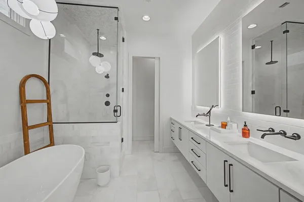 a bathroom with a double vanity sink mirror and bathtub