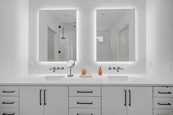 a bathroom with double vanity sink a mirror and shower