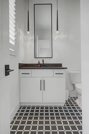 a bathroom with a sink a toilet a mirror and shower