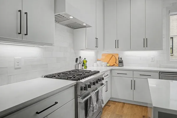 a kitchen with white cabinets and appliances