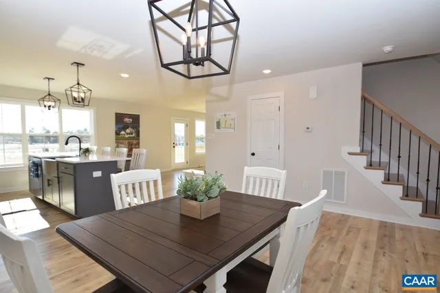 a view of a dining room with furniture a chandelier and wooden floor