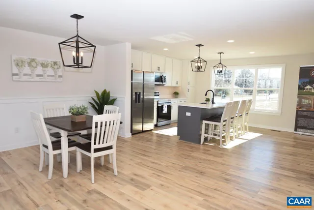 a dining room with furniture wooden floor a rug and a chandelier