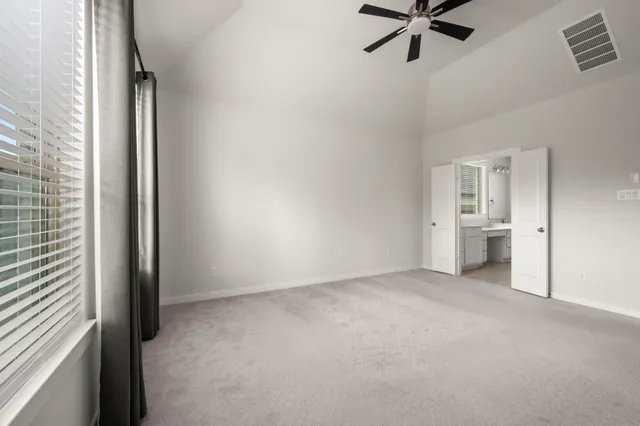 an empty room and a bathroom with sink