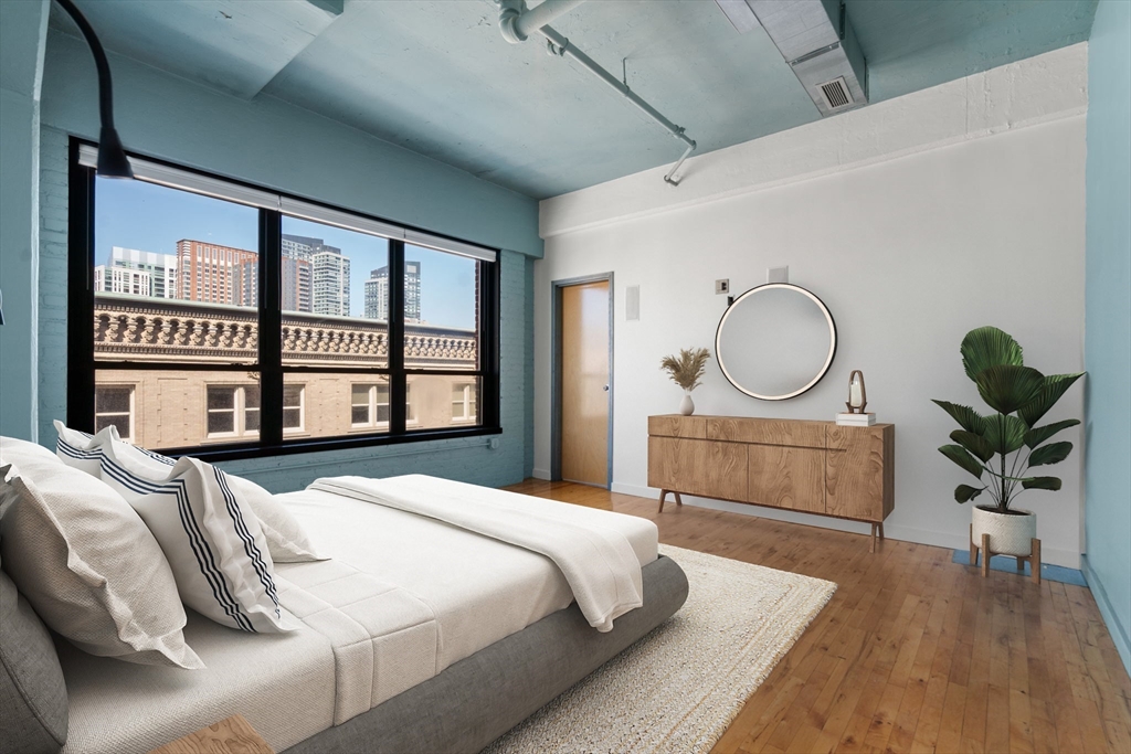 210 Lincoln Street, Unit 601 Boston, MA 02111 - Photo 19 of 29 a bedroom with a large bed and wooden floor
