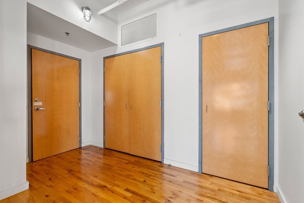 210 Lincoln Street, Unit 601 Boston, MA 02111 - Photo 23 of 29 a view of an empty room with wooden floor and a window