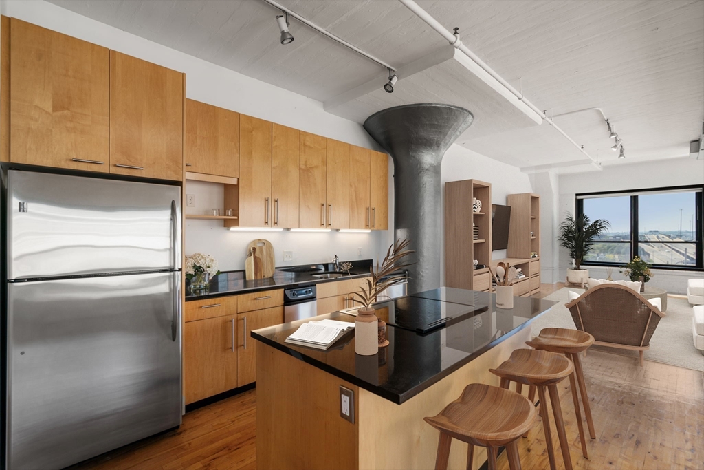 210 Lincoln Street, Unit 601 Boston, MA 02111 - Photo 7 of 29 a kitchen with a table chairs refrigerator and cabinets