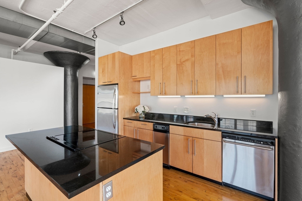 210 Lincoln Street, Unit 601 Boston, MA 02111 - Photo 10 of 29 a kitchen with stainless steel appliances granite countertop a sink a stove and a refrigerator