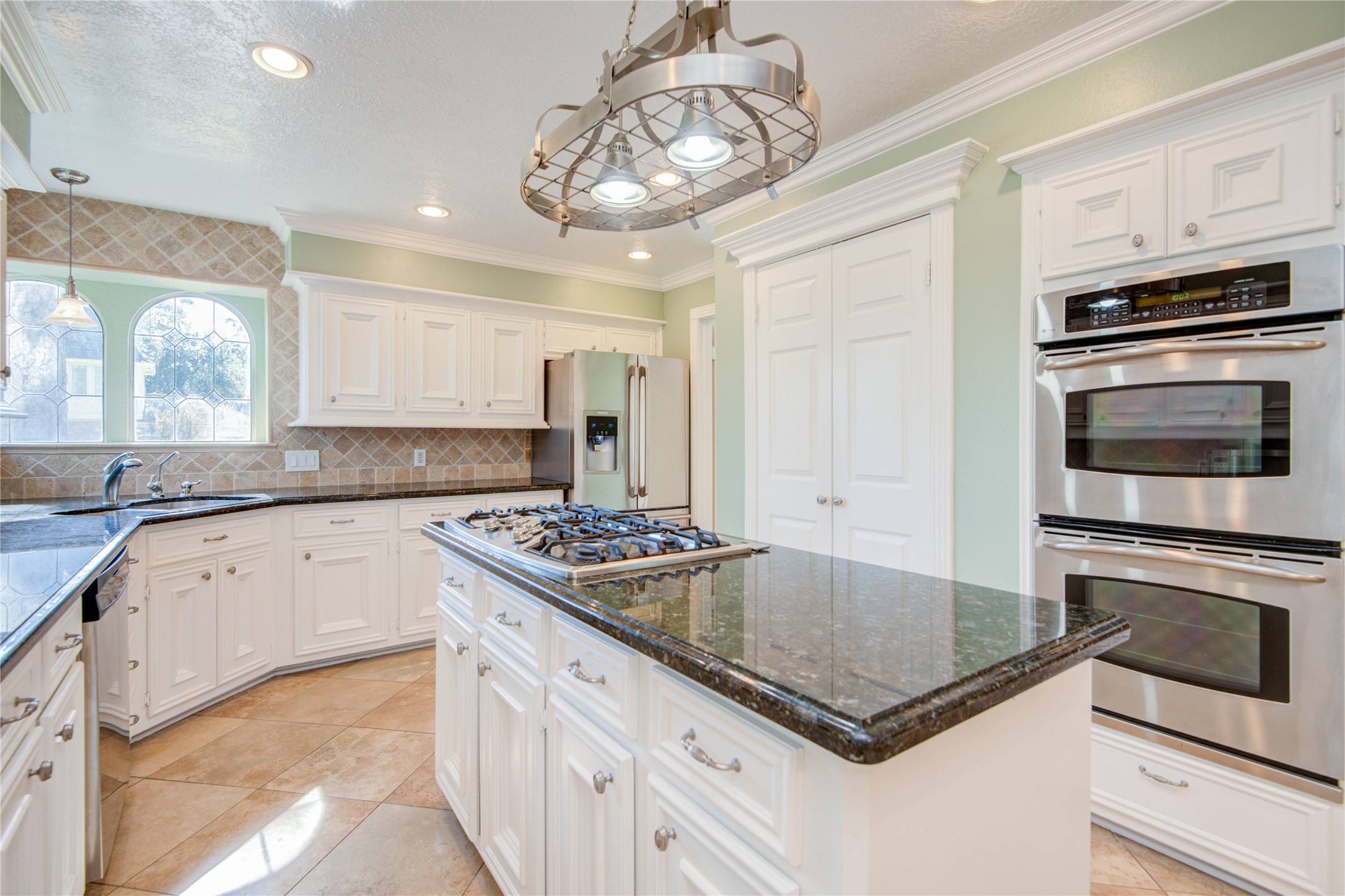 8906 Herts Road Spring, TX 77379 - Photo 12 of 43 a kitchen with stainless steel appliances granite countertop a stove and a granite counter tops with white cabinets