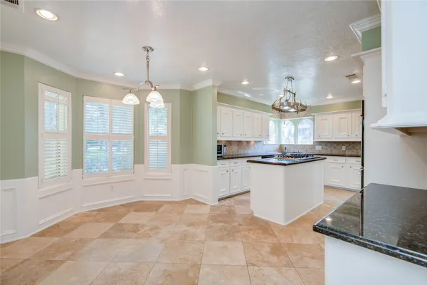 a large kitchen with kitchen island a large counter space and stainless steel appliances