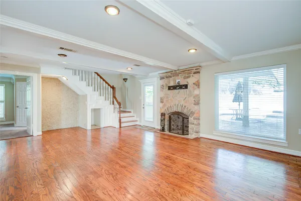 a view of a livingroom with wooden floor a fireplace and window