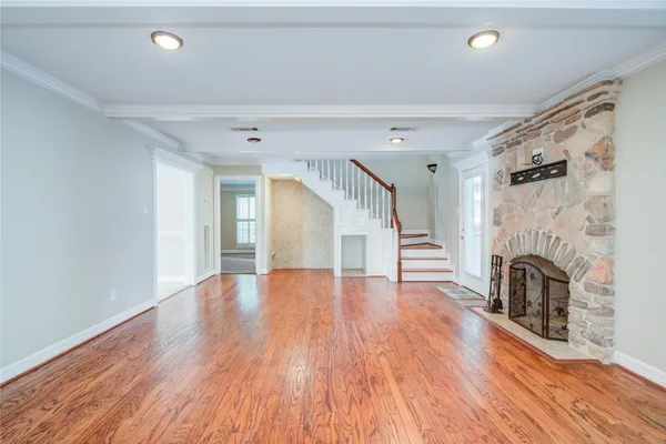 a view of empty room with fireplace and wooden floor