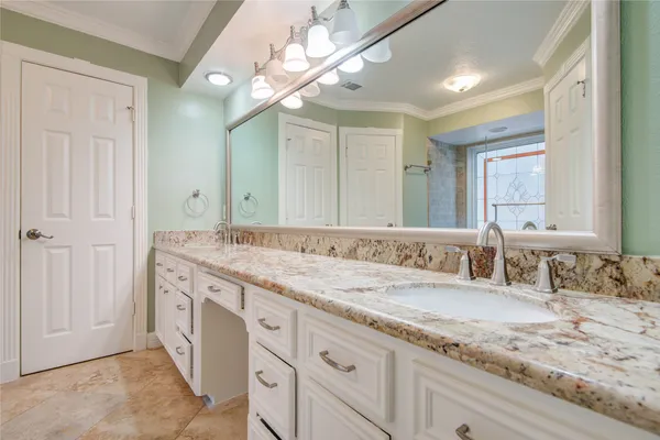 a bathroom with a granite countertop double vanity sink and a mirror