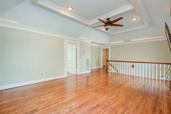 a view of a room with wooden floor a ceiling fan and window