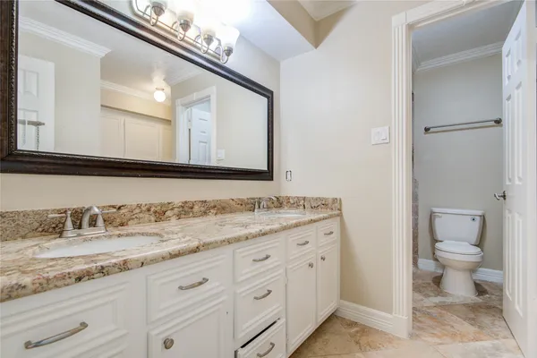 a bathroom with a granite countertop sink mirror and toilet
