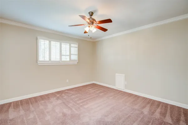 an empty room with window and ceiling fan