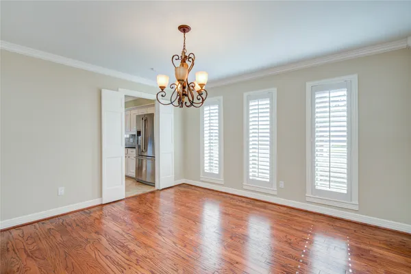 a view of a livingroom with a chandelier wooden floor and windows