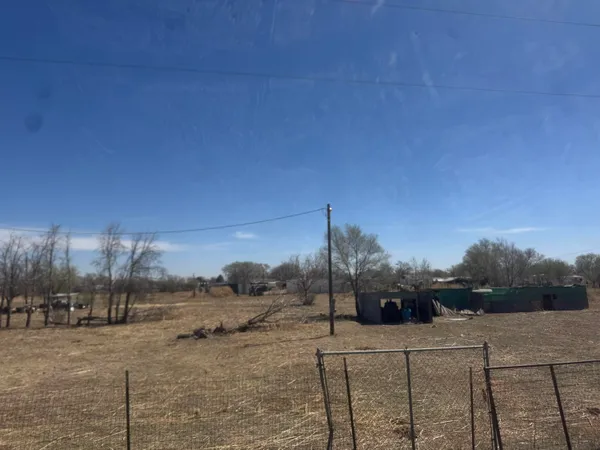 a view of a dry yard with wooden fence