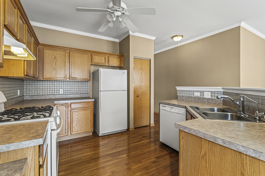 1553 Benzie Circle Romeoville, IL 60446 - Photo 11 of 26 a kitchen with a sink a refrigerator a stove and cabinets
