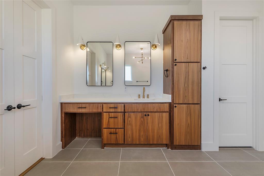 430 Whispering Way Red Oak, TX 75154 - Photo 39 of 40 Wood-finish vanity with a white countertop and gold-tone fixtures