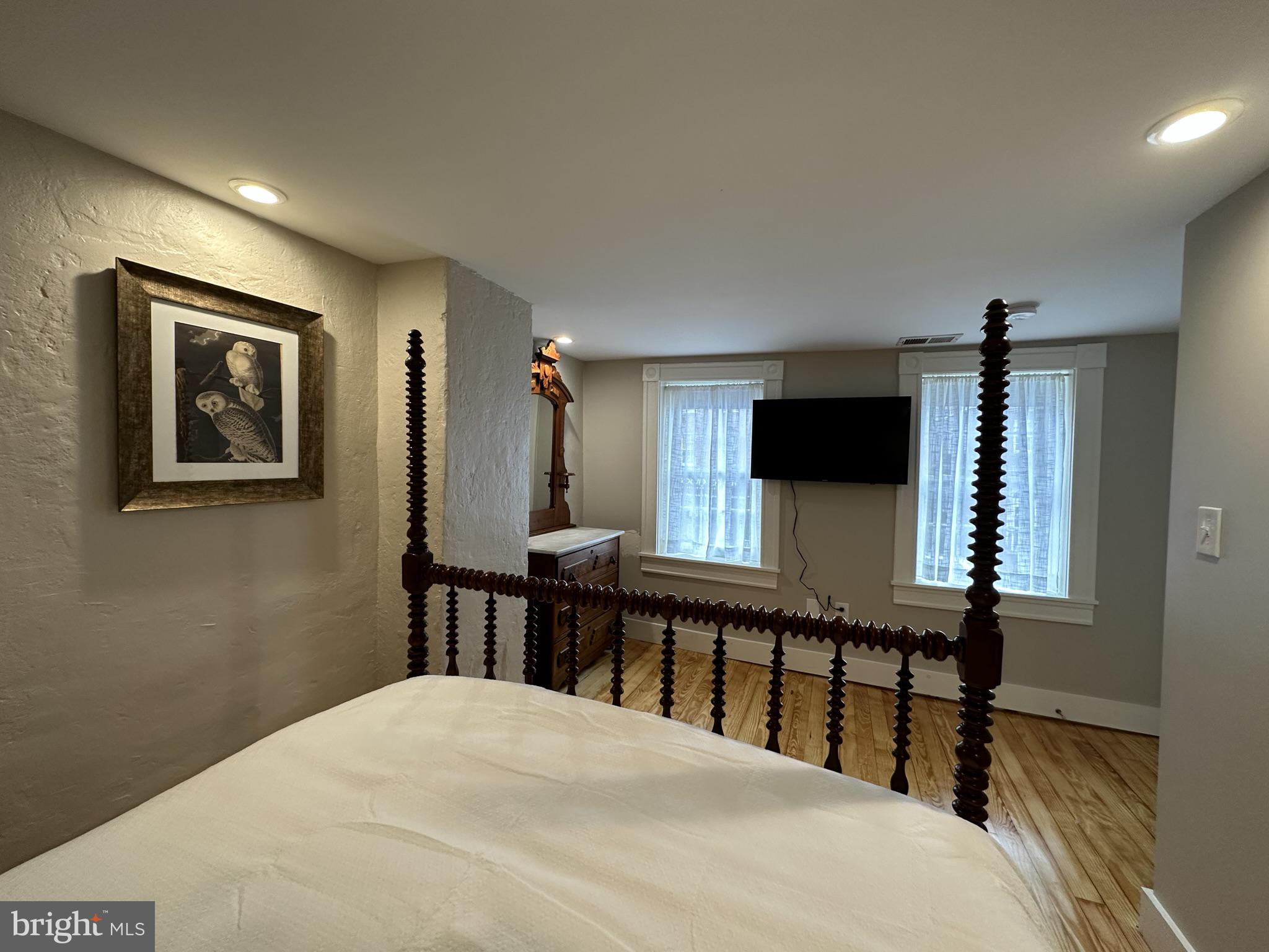1627 Aliceanna Street Baltimore, MD 21231 - Photo 51 of 60 a bedroom with a bed a mirror on desk and a window