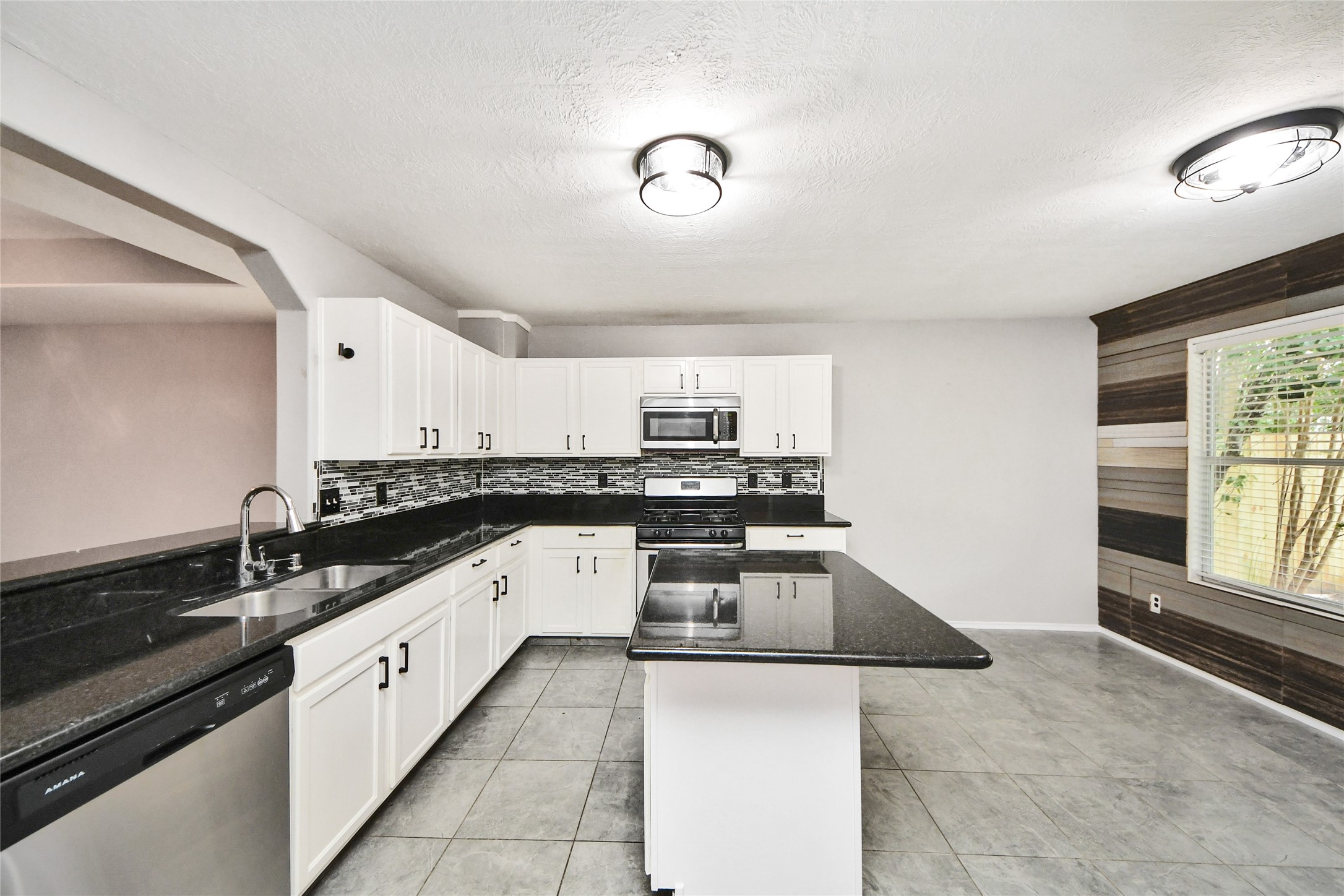 24019 Kingbriar Drive Spring, TX 77373 - Photo 15 of 41 An expansive view of the kitchen showing the stainless steel gas range, built-in microwave, and ample counter space designed for easy meal preparation and entertaining.