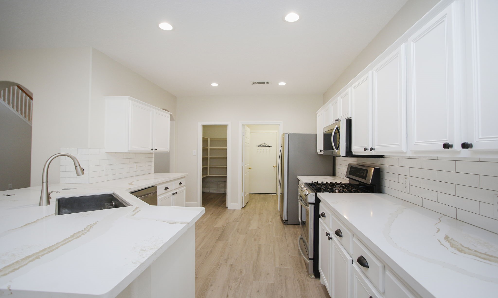 27131 Sunset Pines Drive Spring, TX 77373 - Photo 12 of 44 a kitchen with stainless steel appliances a stove top oven a sink a refrigerator and white cabinets